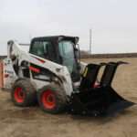 Right side view with opened grapples, on skid loader 68 inch Rock Bucket with Grapple by Messer Attachments fits skid loader, wheel loaders, crawl loaders, front loaders. Compatible with John Deere, Bobcat, Case, New Holland, Kubota, JCB