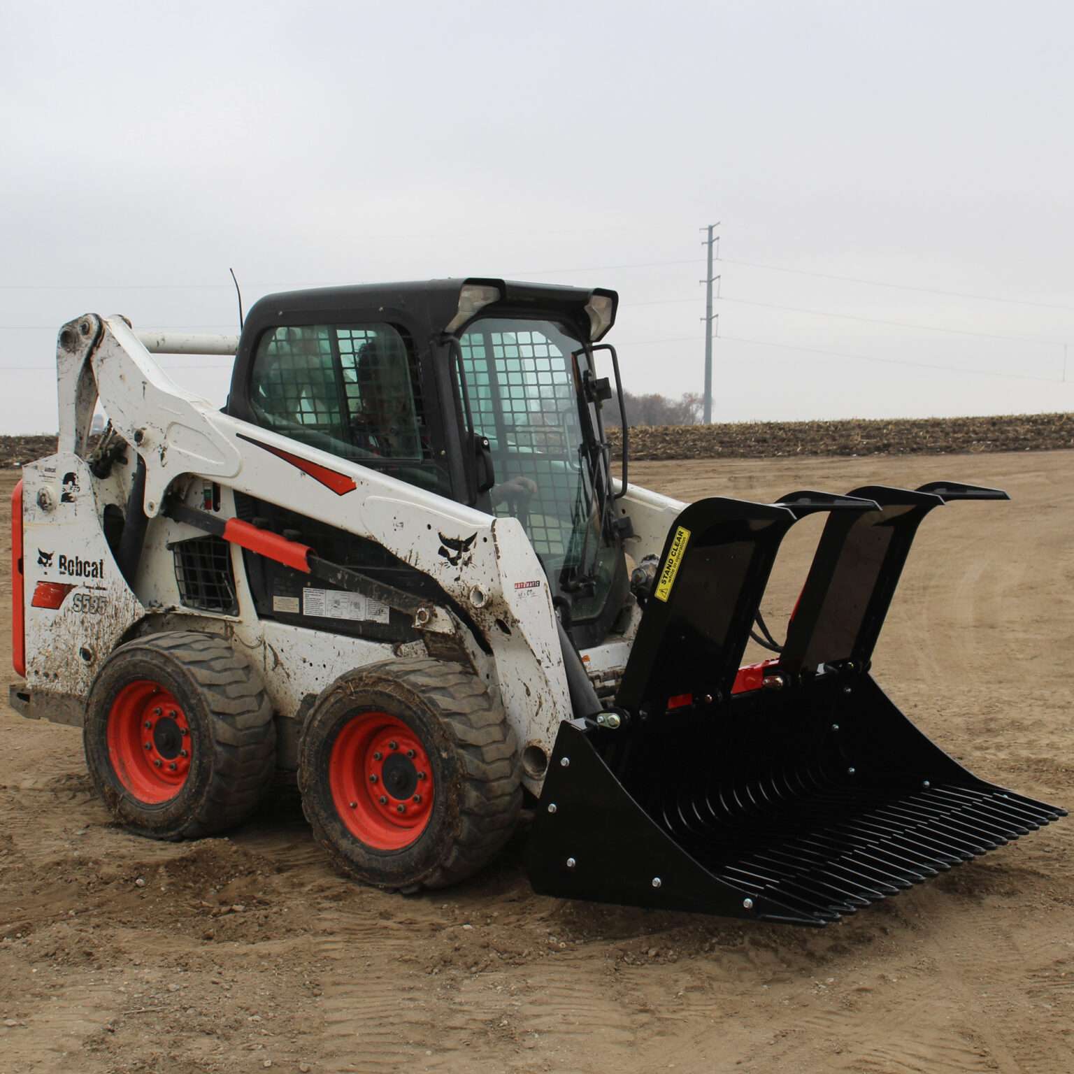 Right side view with opened grapples, on skid loader 68 inch Rock Bucket with Grapple by Messer Attachments fits skid loader, wheel loaders, crawl loaders, front loaders. Compatible with John Deere, Bobcat, Case, New Holland, Kubota, JCB