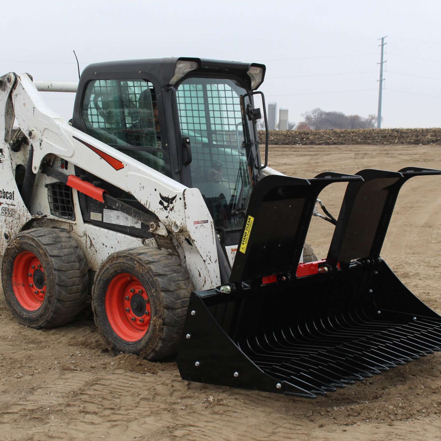 Right side view with opened grapples, on skid loader 75 inch Rock Bucket with Grapple by Messer Attachments fits skid loader, wheel loaders, crawl loaders, front loaders. Compatible with John Deere, Bobcat, Case, New Holland, Kubota, JCB