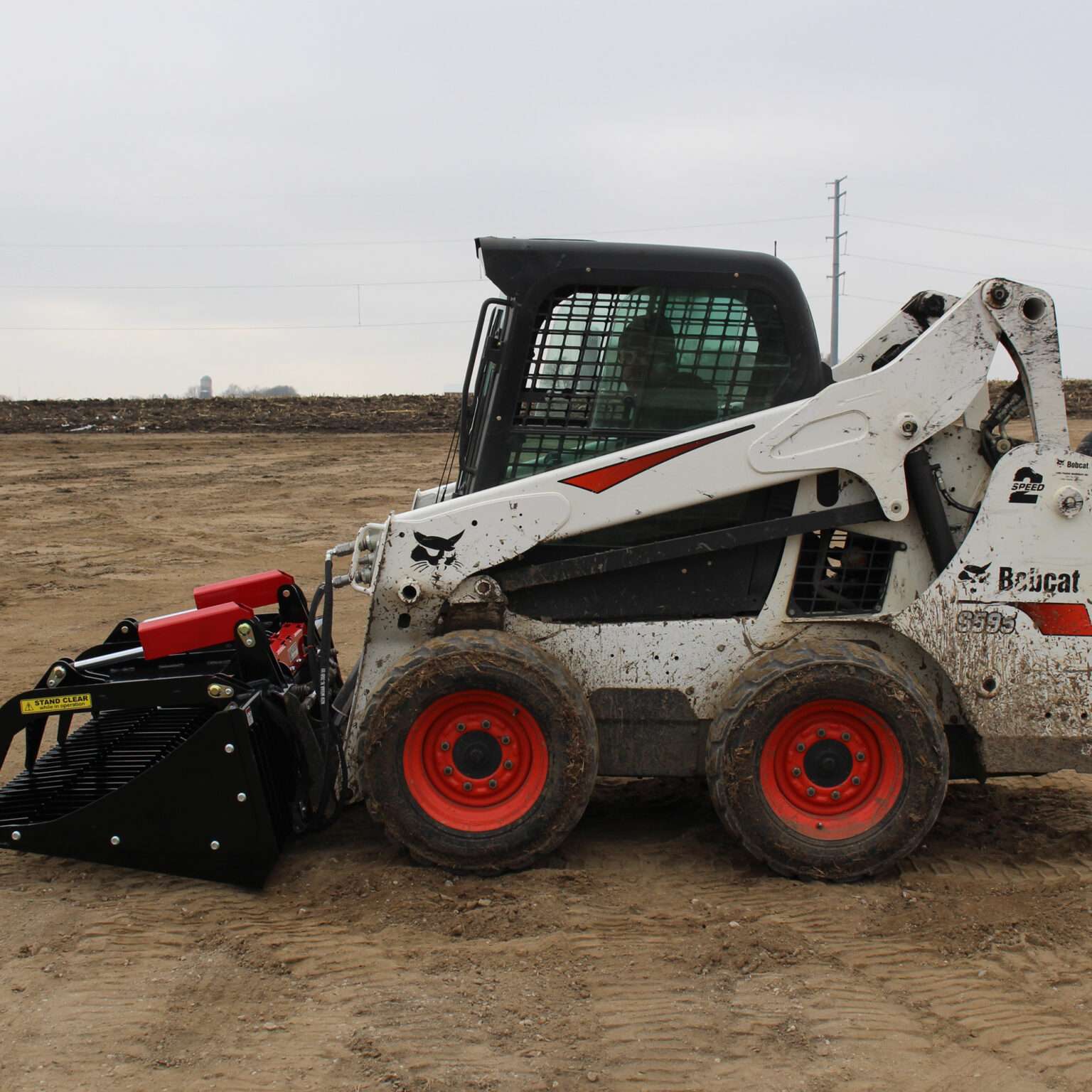 Left side view with closed grapples, on skid loader 82 inch Rock Bucket with Grapple by Messer Attachments fits skid loader, wheel loaders, crawl loaders, front loaders. Compatible with John Deere, Bobcat, Case, New Construction, Kubota, JCB, Caterpillar