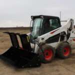 Left side view with opened grapples, on skid loader 82 inch Rock Bucket with Grapple by Messer Attachments fits skid loader, wheel loaders, crawl loaders, front loaders. Compatible with John Deere, Bobcat, Case, New Construction, Kubota, JCB, Caterpillar