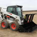 Right side view with opened grapples, on skid loader 82 inch Rock Bucket with Grapple by Messer Attachments fits skid loader, wheel loaders, crawl loaders, front loaders. Compatible with John Deere, Bobcat, Case, New Holland, Kubota, JCB