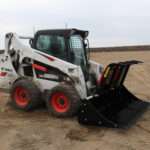 Right side view with opened grapples, on skid loader 88 inch Rock Bucket with Grapple by Messer Attachments fits skid loader, wheel loaders, crawl loaders, front loaders. Compatible with John Deere, Bobcat, Case, New Holland, Kubota, JCB